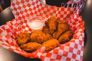 A basket filled with perfectly seasoned chicken wings, accompanied by dipping sauces.