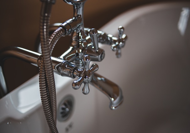 silver water faucet on white ceramic sink