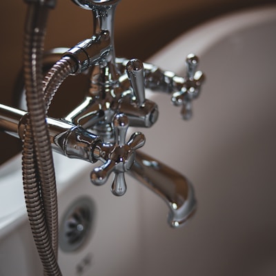 silver water faucet on white ceramic sink