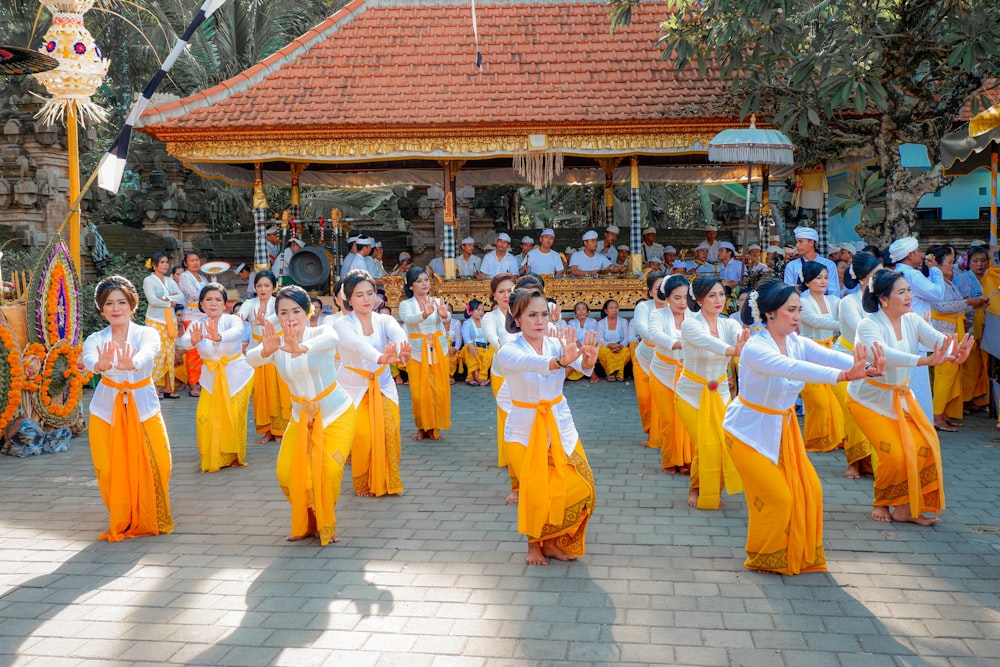 people in yellow and white robe standing on gray concrete floor during daytime