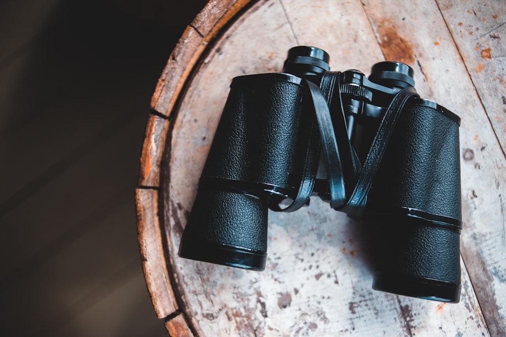 black binoculars on brown wooden table