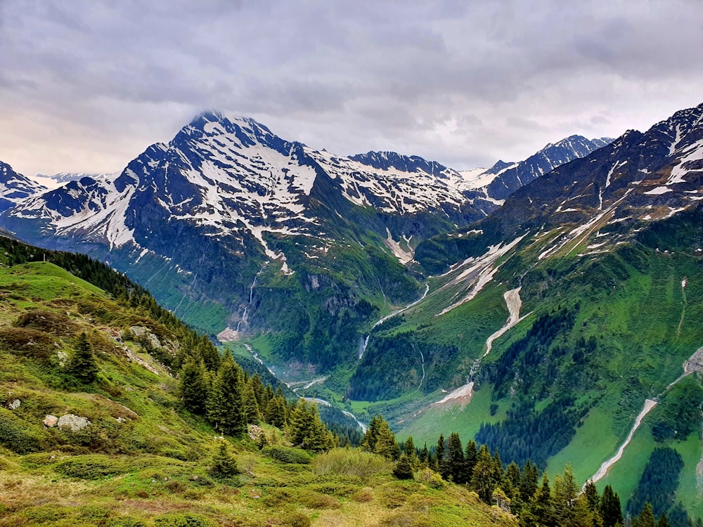 green and white mountains under cloudy sky during daytime