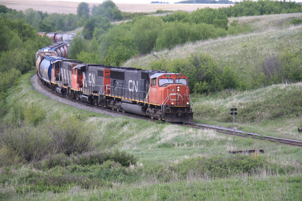 red train on rail tracks during daytime