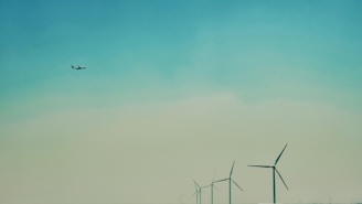 A serene landscape of wind turbines turning under a clear sky.