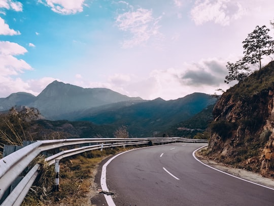 gray concrete road near mountain during daytime in Kerala India