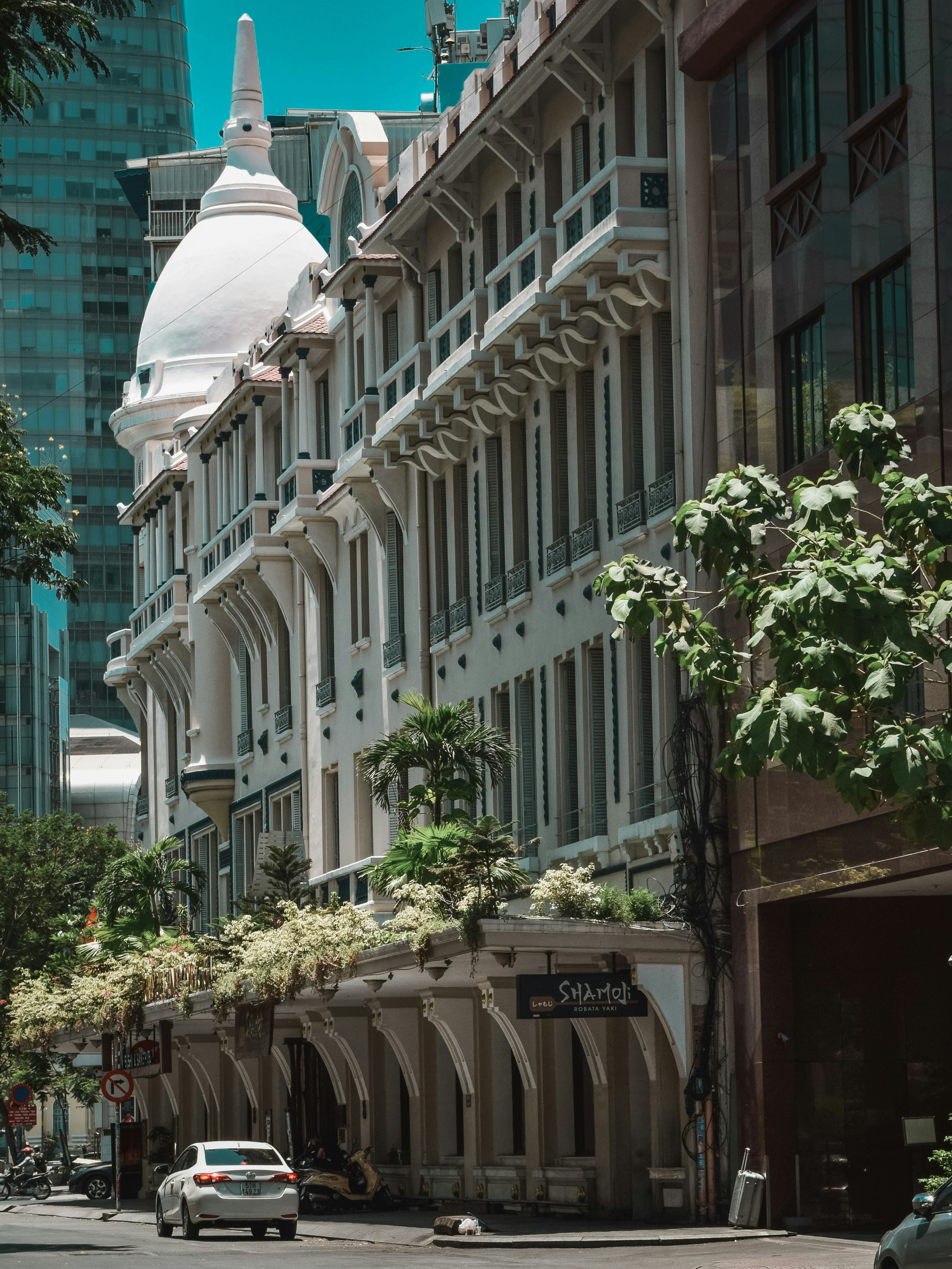green trees in front of white concrete building during daytime