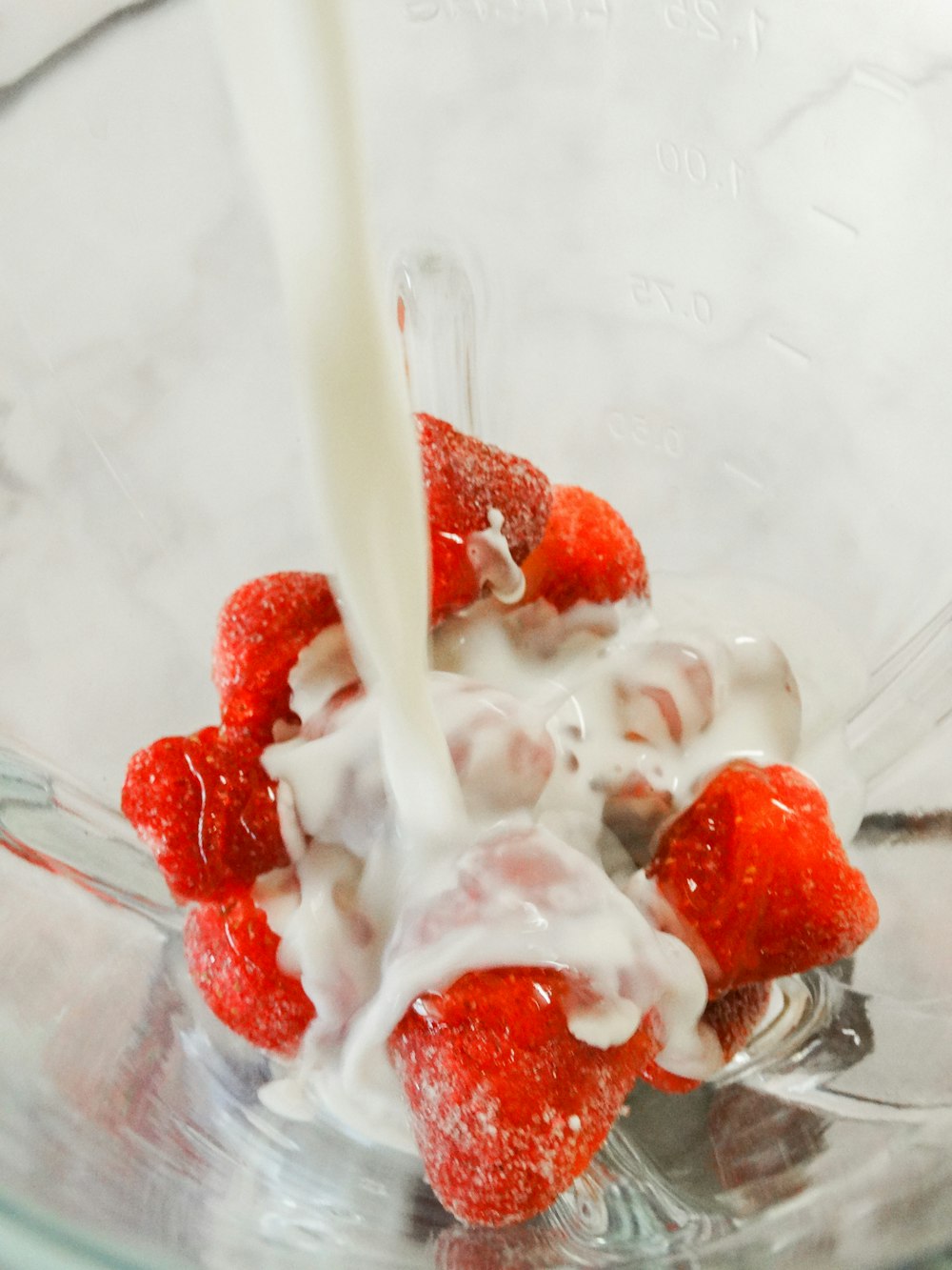 white ice cream with strawberry on clear glass bowl