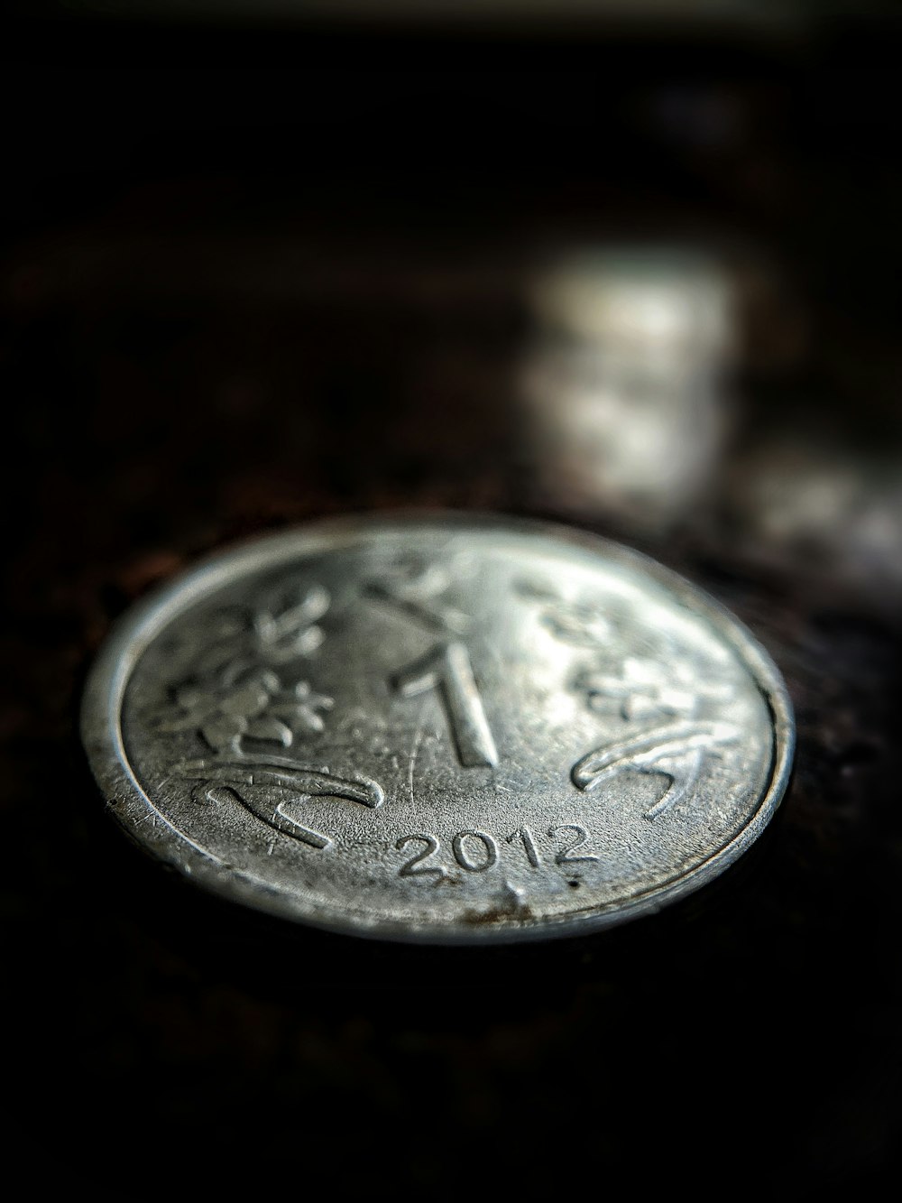 silver round coin on brown surface