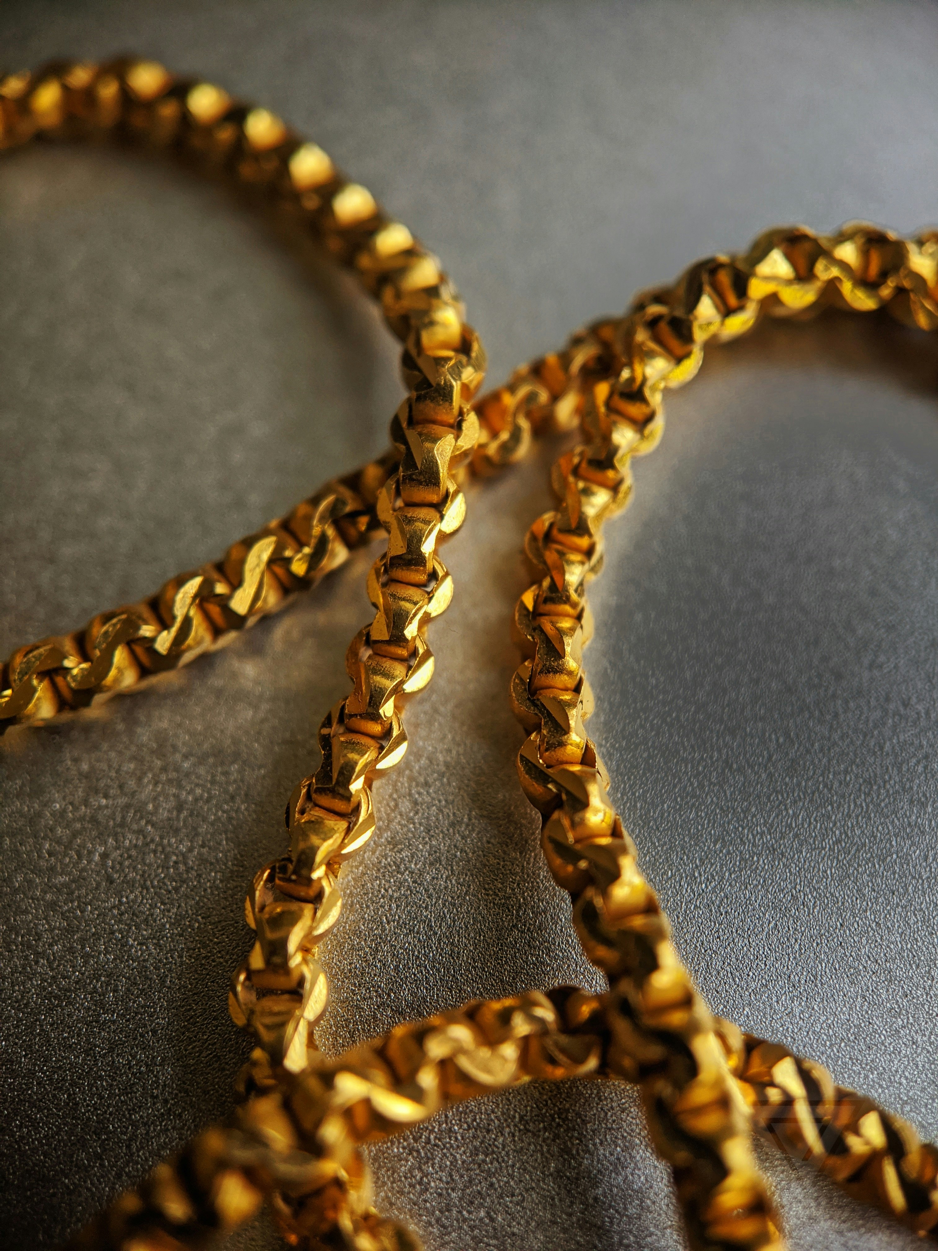 gold chain necklace on gray textile