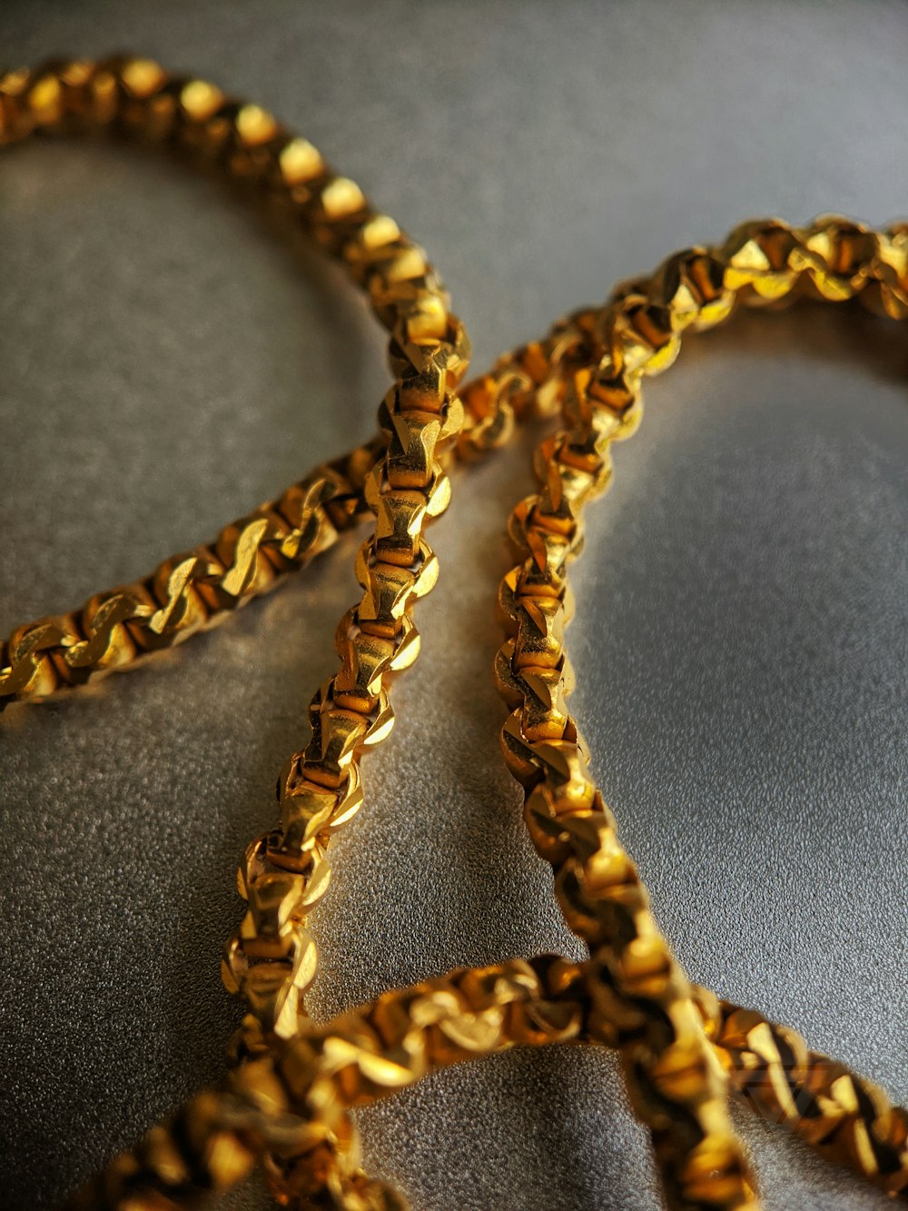 Collar de cadena de oro sobre textil gris