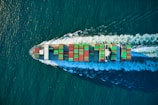 aerial view of blue and white boat on body of water during daytime
