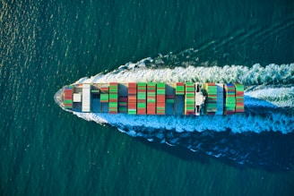 aerial view of blue and white boat on body of water during daytime