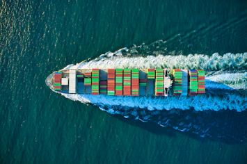 aerial view of blue and white boat on body of water during daytime