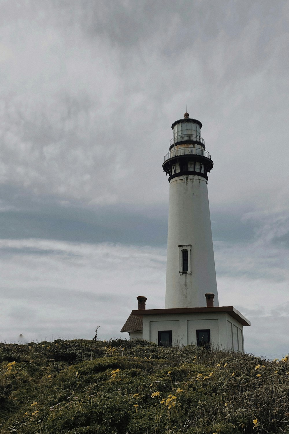 Phare blanc et noir sous des nuages blancs pendant la journée