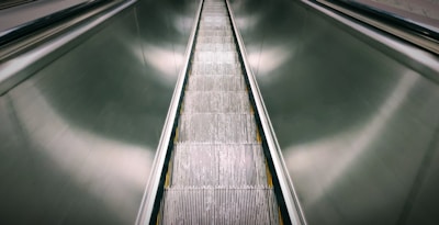Finished elevator guide rails stacked neatly, showcasing metallic luster and sharp edges.