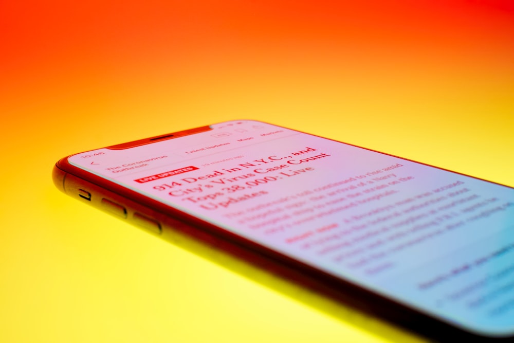 Schwarzes Android-Smartphone auf orangefarbener Oberfläche