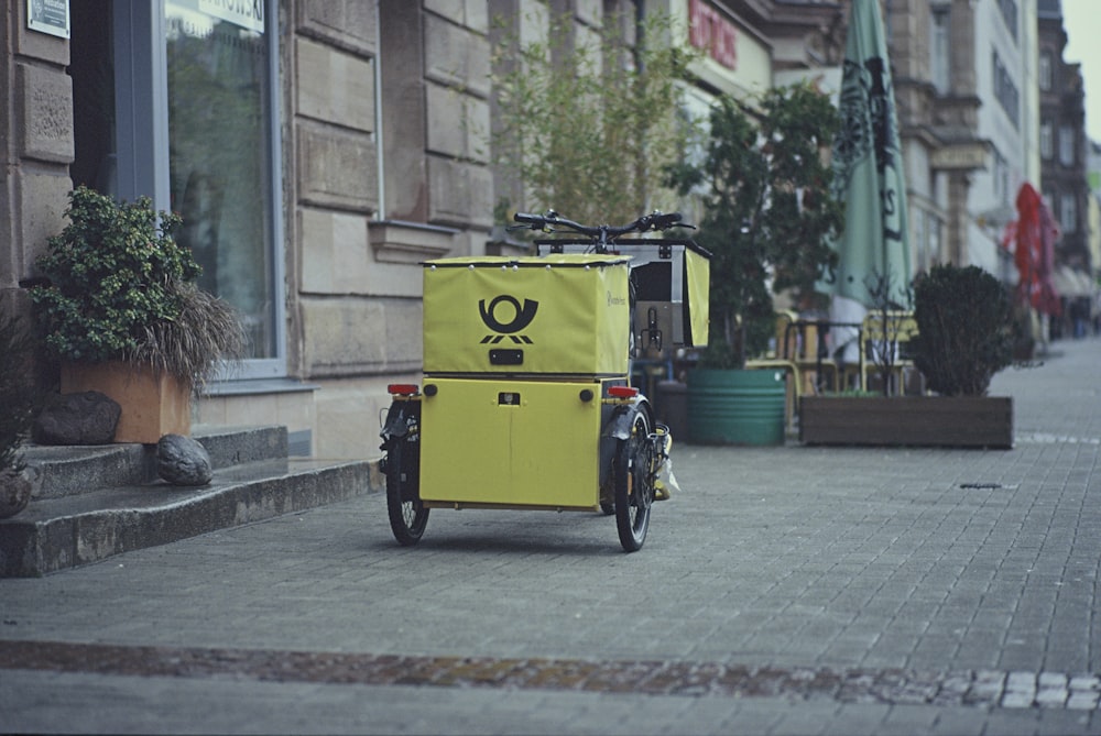 Bicicleta negra estacionada al lado de la caja amarilla