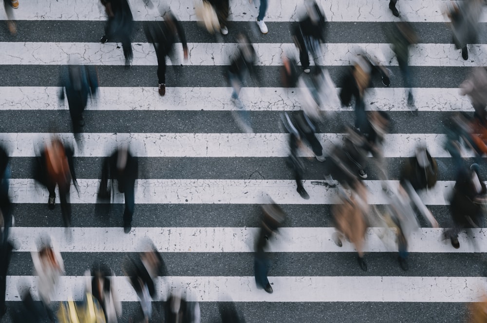 persone che camminano sulla corsia pedonale durante il giorno