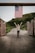 woman in white and black dress standing on pathway with us flag on her back