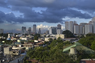 city with high rise buildings under gray clouds during daytime