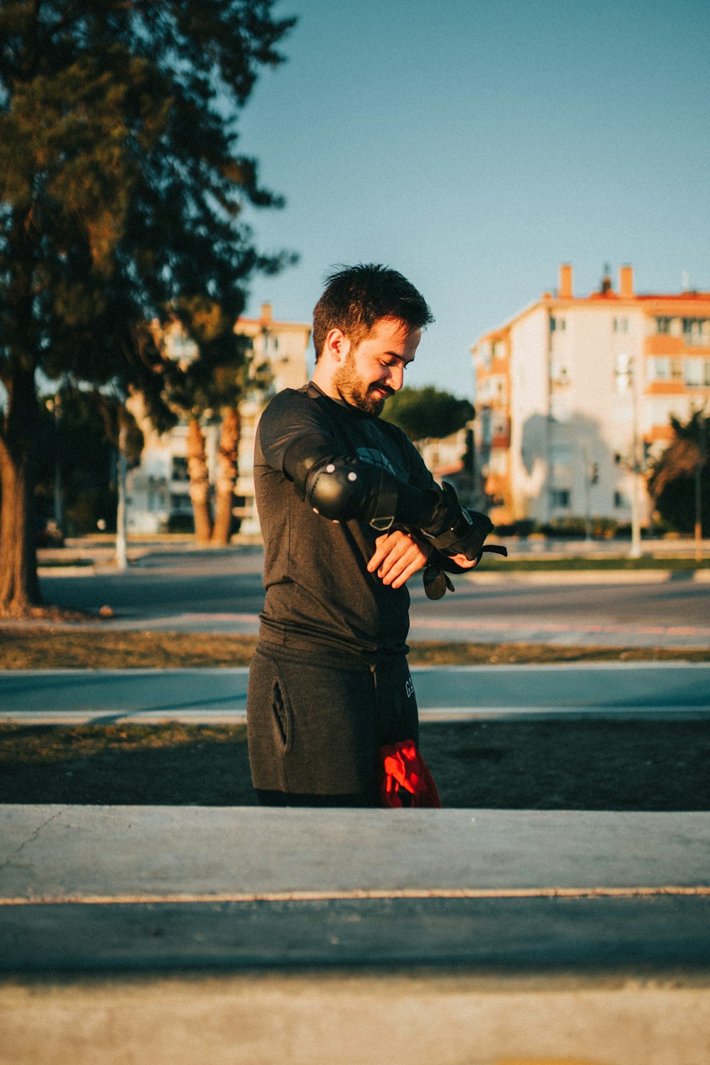 man in black jacket holding black dslr camera standing on road during daytime