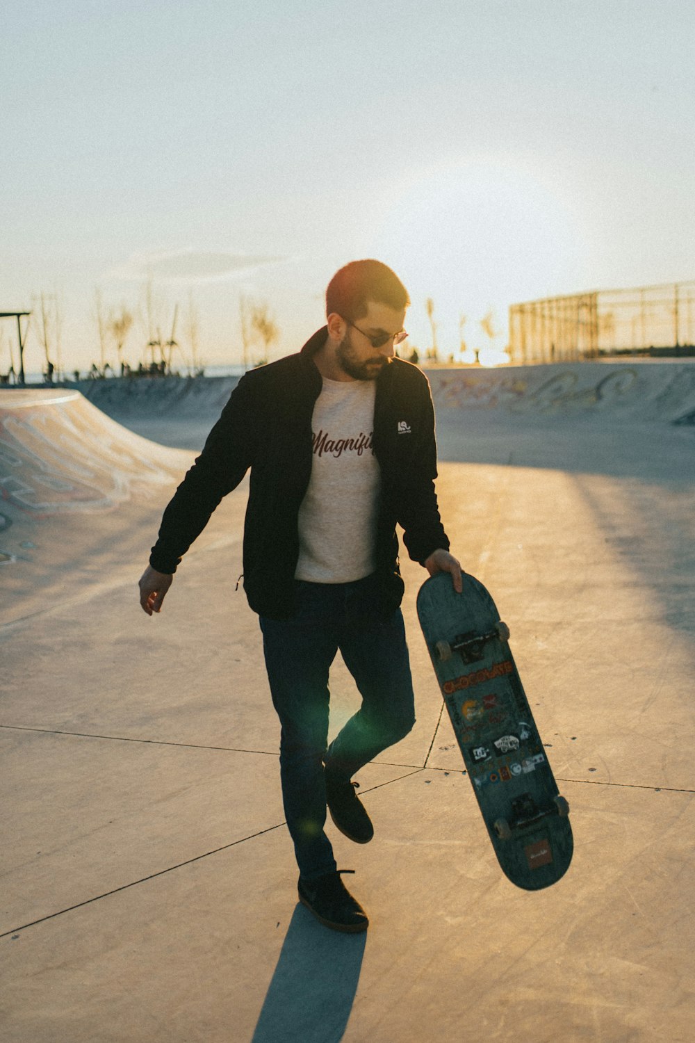 woman in black jacket and black pants holding black skateboard