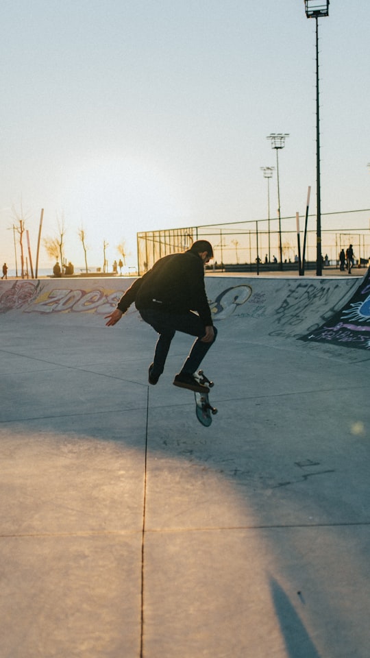 man in black jacket riding on black skateboard during daytime in Bostanlı Turkey