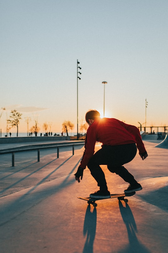 man in red shirt riding skateboard during daytime in Bostanlı Turkey