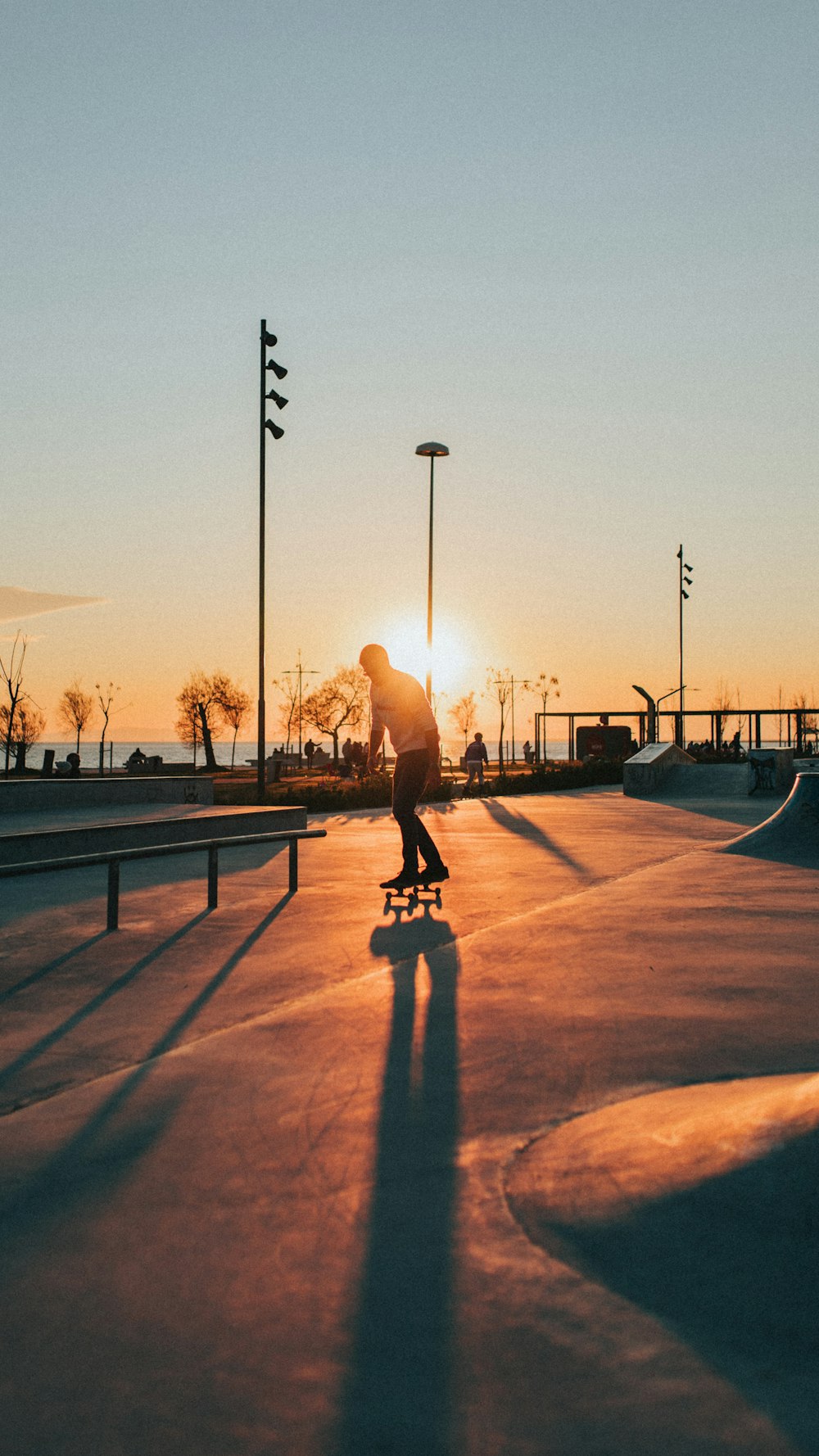 Silhouette einer Person, die während des Sonnenuntergangs im Park spazieren geht