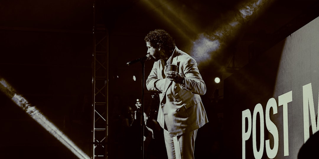 man in white suit singing on stage