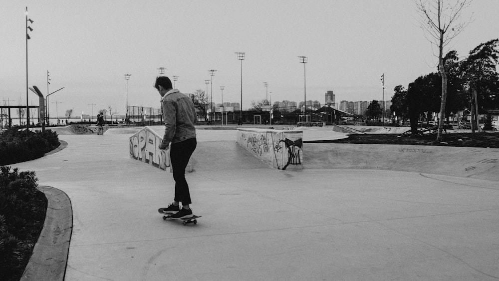 man in black shirt and pants playing skateboard in grayscale photography