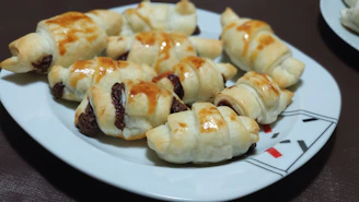Golden flaky croissants and chocolate pastries arranged invitingly on a rustic wooden table.