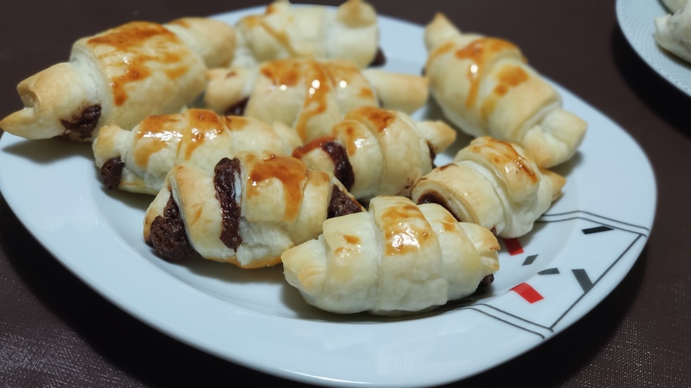Close-up of a freshly baked chocolate-filled brioche with a glossy golden crust.