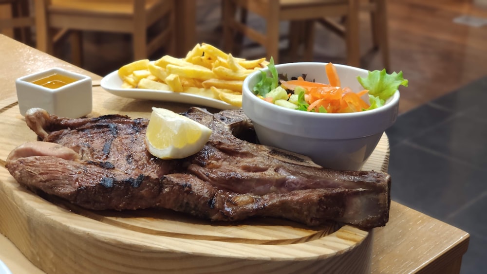 grilled meat with fries and sauce on white ceramic plate