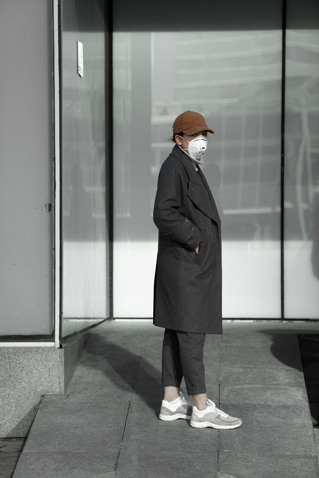 woman in black coat standing in front of glass door