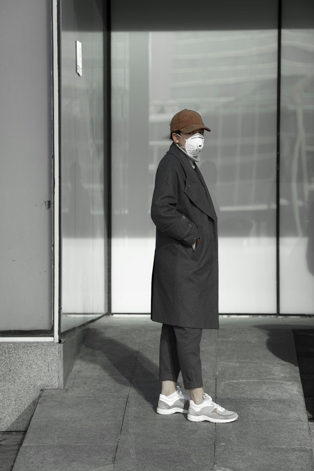 woman in black coat standing in front of glass door