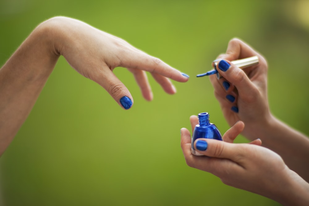 person holding blue and white plastic bottle