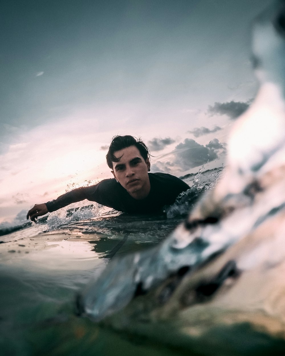 man in black tank top swimming on water