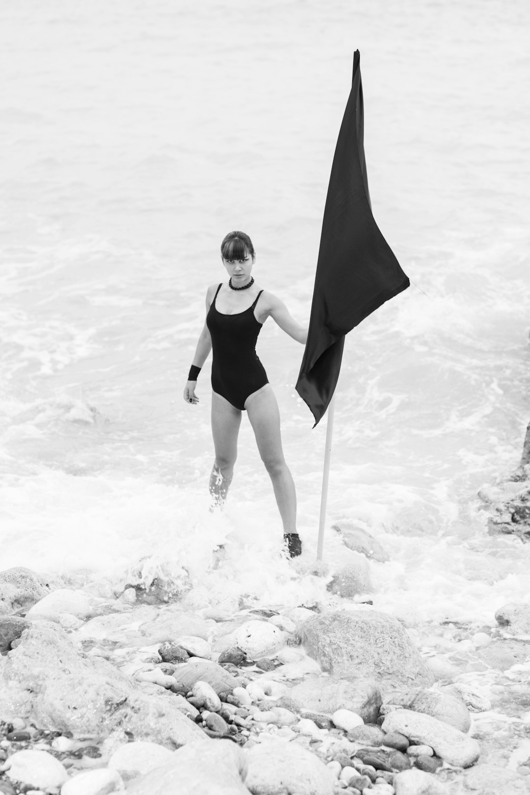 woman in black one piece swimsuit holding umbrella