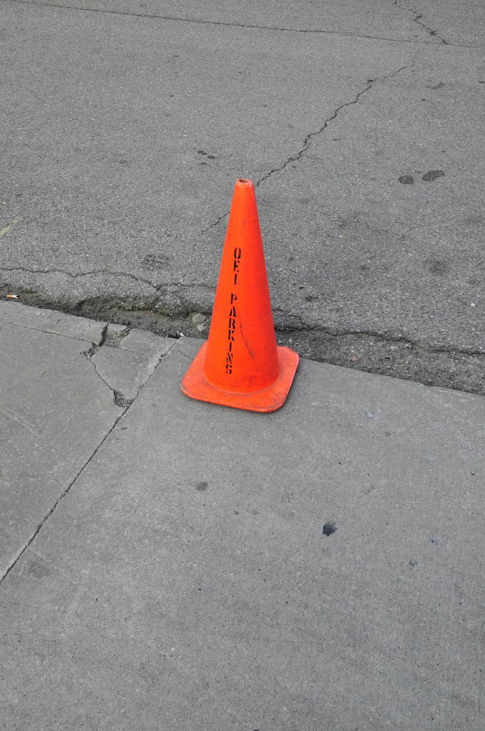 orange traffic cone on gray concrete pavement