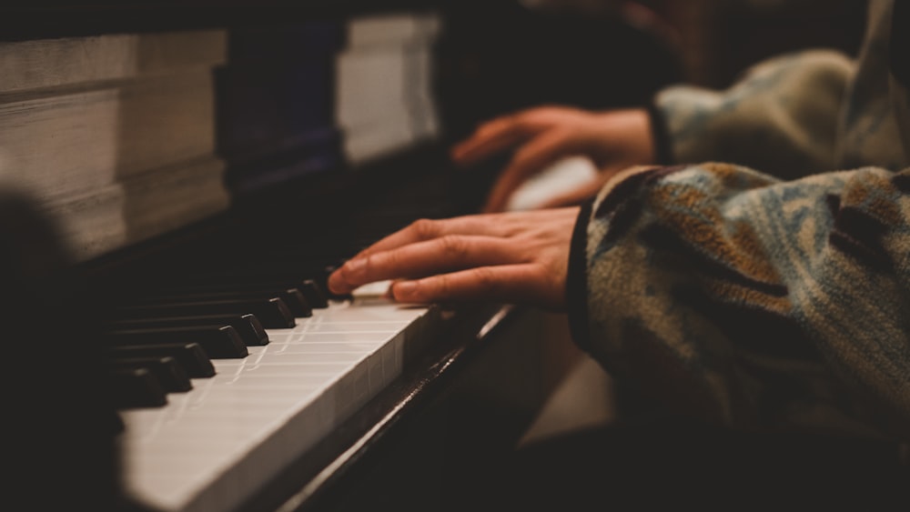 Foto persona tocando el piano en fotografía en escala de grises – Imagen  Marrón gratis en Unsplash