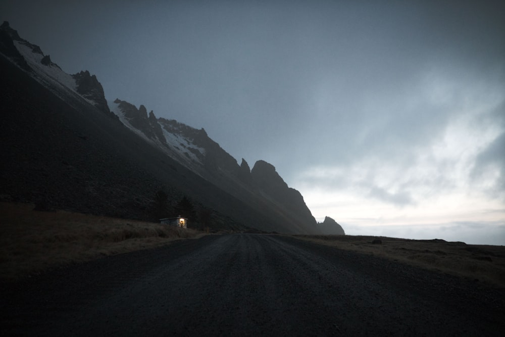 gray road between brown mountains under white sky during daytime