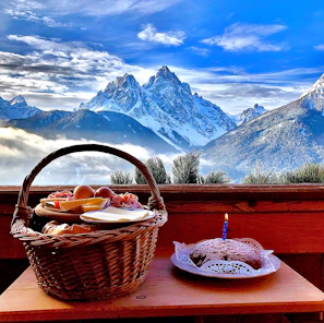 Cozy Patagonian mountain landscape with soft morning light and local artisanal products displayed on a rustic wooden table.