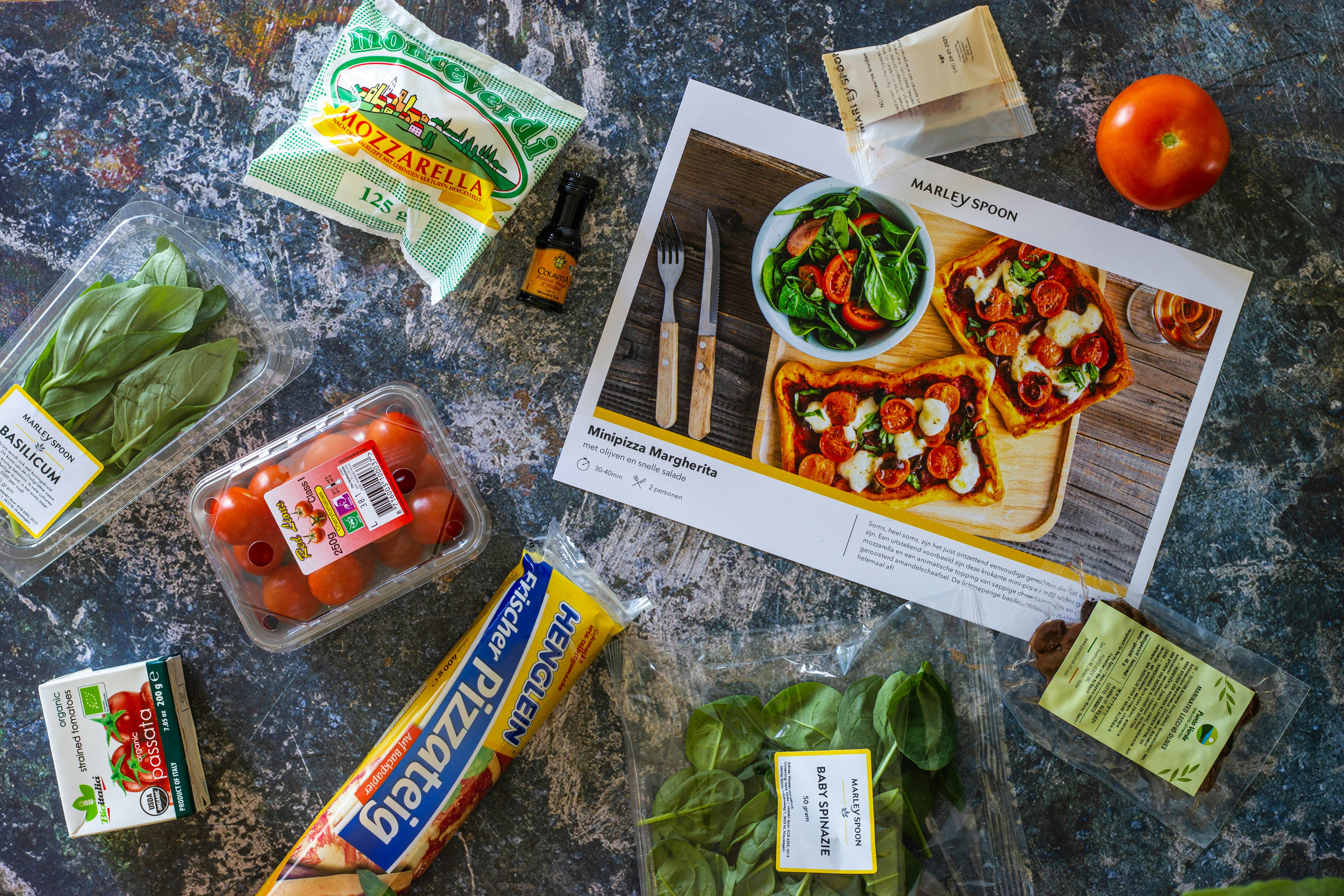 A clean, organized kitchen counter with fresh vegetables and a smartphone displaying the EasyHome meal planner app.