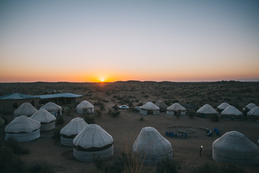 white tent on green grass field during sunset