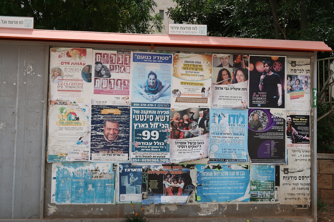 Neighborhood advertising board. Due to the lockdown, ads have not been replaced in a while, and are slowly fading and peeling.