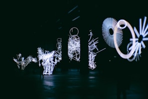A dynamic light installation glowing in a darkened Paris gallery space