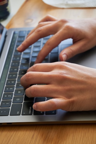 persons hand on black and silver laptop computer