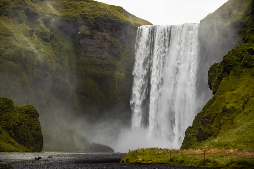 waterfalls on green grass field during daytime