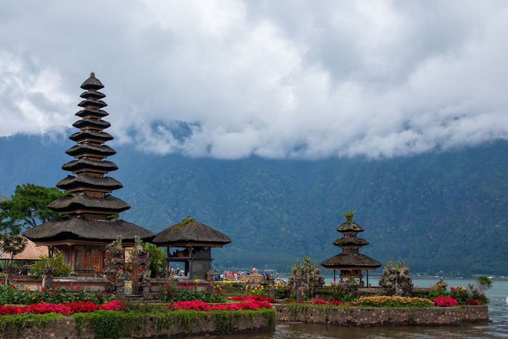 brown and black temple near green mountain under white clouds during daytime